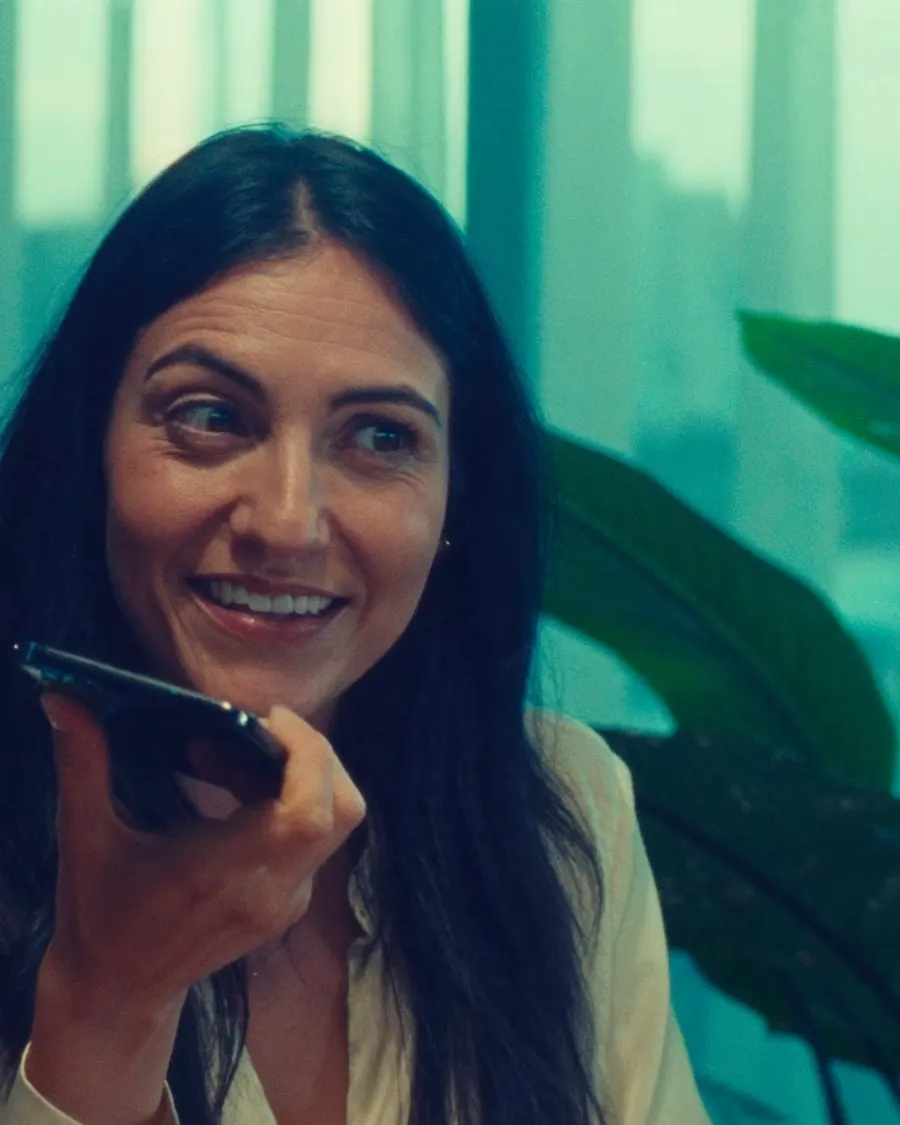 Una analista graba una nota de voz en su teléfono, en su oficina.